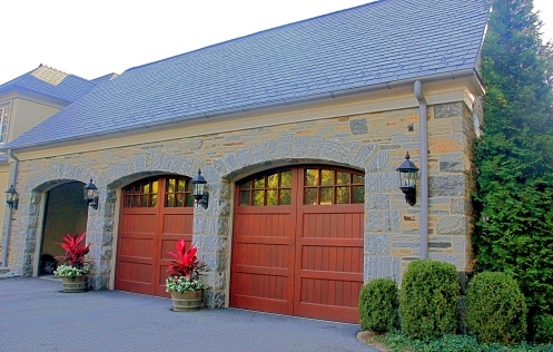 Stone garage addition with custom wooden doors